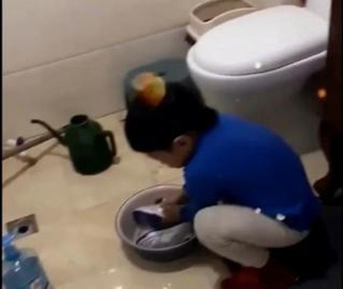 Hình ảnh bé trai 5 tuổi tự mình giặt giày vì lo mẹ mệt khiến cộng đồng mạng Trung Quốc xúc động. Ảnh: SCMP